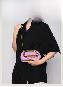 Detail of purple marble acrylic clutch bag with gold chunky metal handle and chain strap