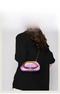 Detail of light purple marble acrylic clutch bag with bold gold buckle and chain strap