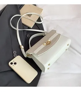 Detailed view of white PU leather handbag with beige textured woven flap and gold clasp