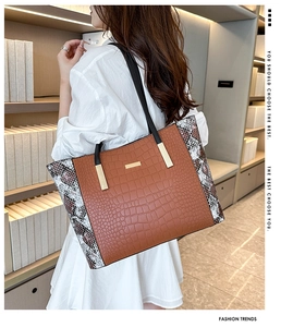 Dettaglio della borsa tote grande con motivo a coccodrillo marrone e patchwork stampa serpente