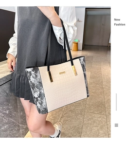 Dettaglio borsa shopper beige coccodrillo con pannelli laterali serpente e finiture oro