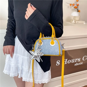 Mini color-block bowling bag with yellow leather handles and denim finish shown on model