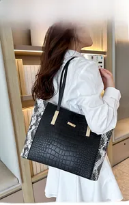 Dettaglio della borsa tote con stampa coccodrillo, pannelli serpente e fibbie d'oro
