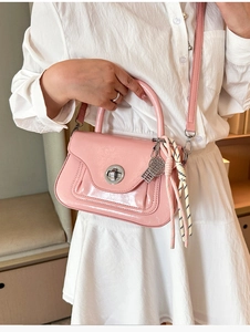 Dettaglio borsa in pelle lucida rosa con chiusura a girello e ciondolo a racchetta