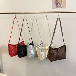 Fünf minimalistische geflochtene Umhängetaschen in verschiedenen Farben am Ständer