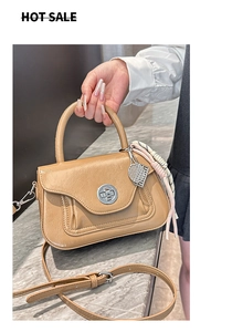 Dettaglio della borsa in pelle cerata kaki con chiusura in metallo e foulard in seta