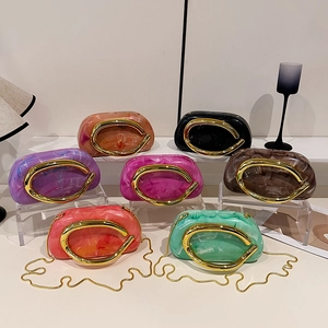 Acrylic evening clutches with marble patterns and gold metal handles in seven colors