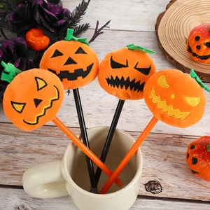 Halloween pumpkin plush ballpoint pens set with embroidered expressions on a desk