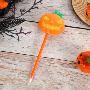 Close-up of Halloween ballpoint pen with orange plush pumpkin and cute embroidered face