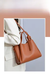 Side view of a brown pebbled leather bucket bag worn by a model with a slim strap