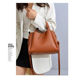 Detail of soft brown leather tote with litchi texture and elegant knot handle