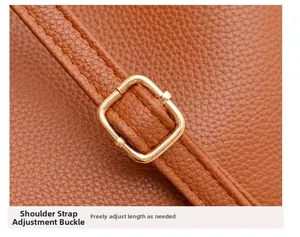 Detail of caramel lychee leather strap with adjustable gold metal buckle on bucket bag