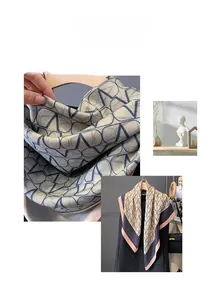 Detailed close-up of champagne silk scarf featuring navy V-pattern and contrast hem