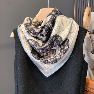 Elegant floral print scarf with camellia patterns styled on a black sequin top vest