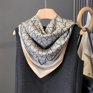 Elegant grey-blue silk scarf with geometric V-pattern over a chic black sequin vest