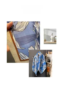Detailed macro view of blue floral silk scarf featuring herringbone weave and rolled edges