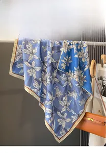 Close-up of double-sided silk scarf featuring large white floral prints on navy blue fabric