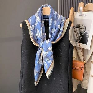 Elegant sky blue floral silk scarf with lily print over a black sequin dress