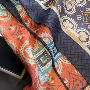 Elegant silk square scarf with paisley and geometric patterns in orange and navy blue