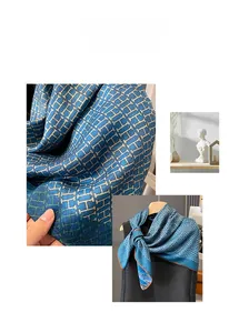 Detailed view of blue silk scarf featuring H-letter jacquard texture and orange edges