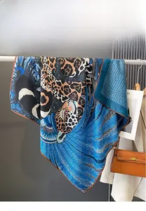 Close-up of leopard and feather print silk scarf with luxury blue H letter patterns