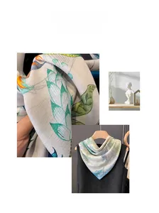 Close-up of lightweight silk scarf featuring elegant green leaf and orange floral prints