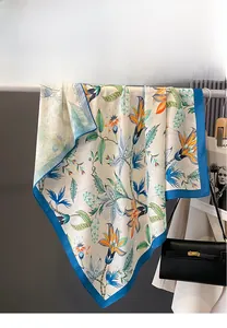 Detailed view of floral double-sided printed silk scarf with navy blue hemmed edges