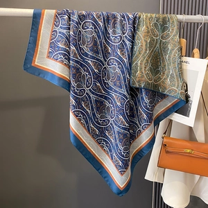 Blue paisley satin square scarf with geometric border styled with a trench coat