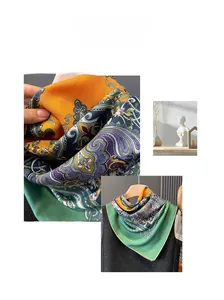 Détail d'un foulard en soie à motif Paisley vert et orange avec texture satinée