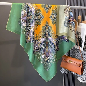 Détail d'une écharpe en soie à motif paisley vintage avec sac à main élégant