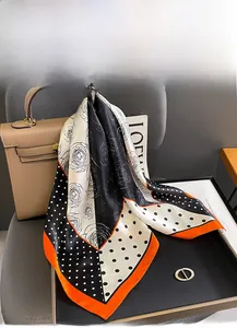 Détail du foulard en soie avec fleurs de camélia et bordure orange au style luxueux