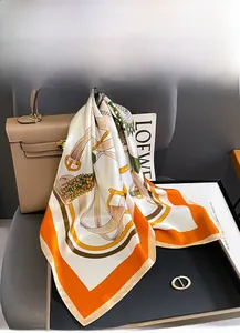 Detail of luxury mulberry silk square scarf with vintage belt chain print on handbag