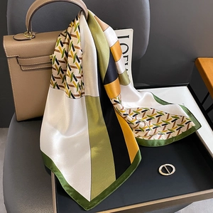 Luxe zijden sjaal met geometrische kleurblokken op een klassieke bruine leren handtas