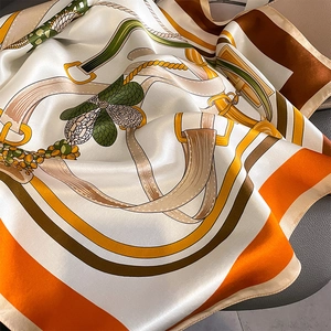 Detailed macro view of equestrian print silk scarf with luxury buckle and belt pattern
