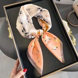 Floral print silk neck scarf with peach pink and ivory tones in elegant knotted style