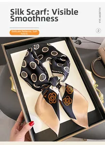 Close-up of premium mulberry silk scarf with elegant camellia floral pattern on black