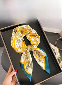 Close-up of vintage mulberry silk square scarf with floral pattern on a black tray