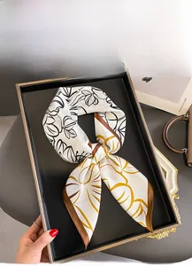 Detail of mulberry silk square scarf featuring yellow leaf prints and brown borders