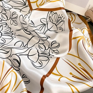 Vintage floral silk scarf with geometric border and satin finish on leather bag