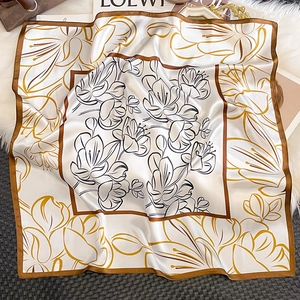 Detailed close-up of a vintage floral silk square scarf with satin finish on plush background