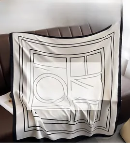 Gros plan d'un foulard carré en soie avec motif géométrique sur tissu en sergé