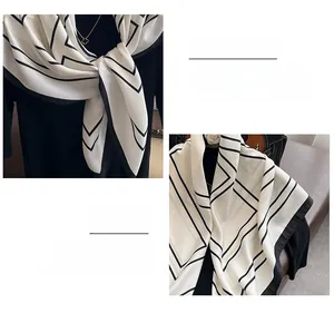 Vue détaillée d'un foulard en soie blanche avec lignes noires et bords roulottés