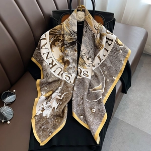British style large square silk scarf with horse print draped over a black leather bag