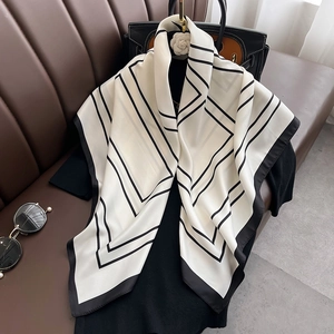 Foulard en soie classique noir et blanc avec motifs géométriques sur une tenue chic