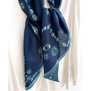 Elegant navy blue skinny scarf with eye pattern and geometric prints on white shirt