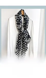 Close-up of black and white polka dot scarf with floral pattern on a white shirt