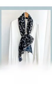 Macro detail of navy blue skinny scarf with white feather print on a white shirt