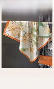 Detail eines doppelseitigen Seidenschals mit Blumendruck und eleganten Farbkanten