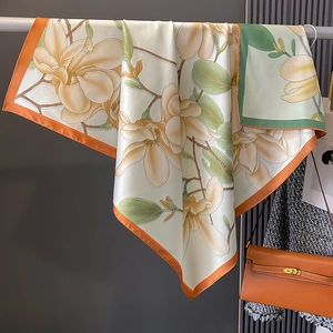 Vintage Seidenschal mit Magnoliendruck und orange-grünem Rand in modischer Kulisse