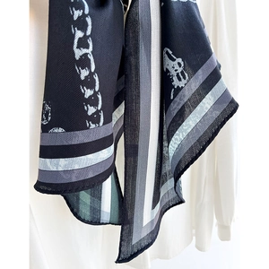 Navy chain print silk scarf with stripe pattern draped over a white shirt